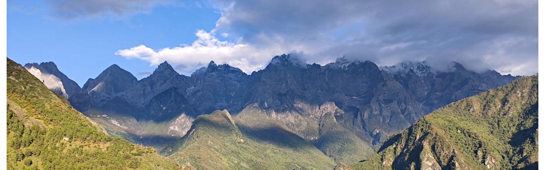 The Jade Dragon range in afternoon light under scattered cloud